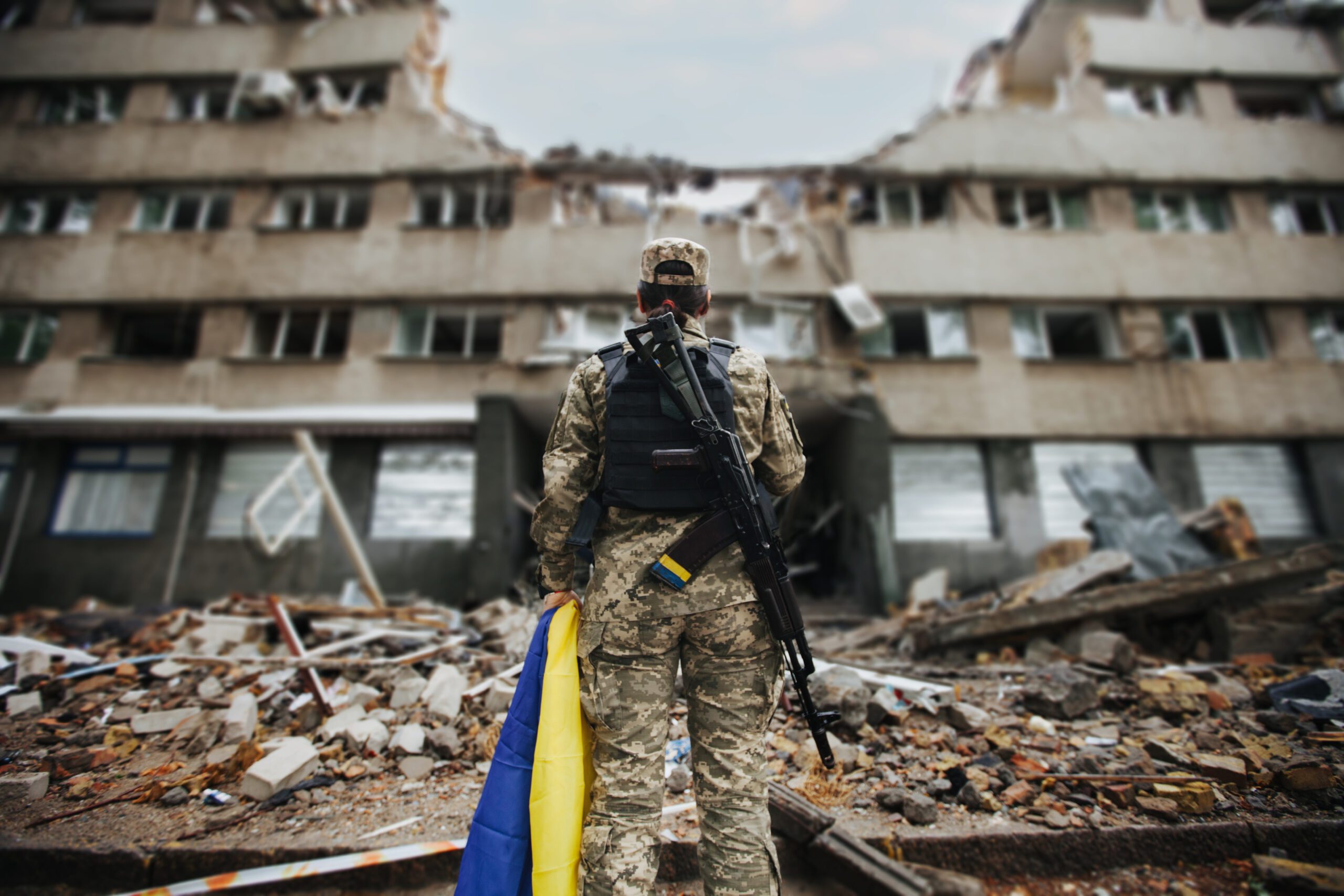 Ukraine conflict soldi standing in front of destroyed building